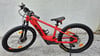 Ein rotes KTM Kinder-E-Bike mit dicken Reifen steht auf Schotter.