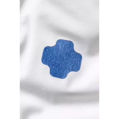 Ein blauer kreuzförmiger Aufnäher auf weißem Hintergrund. Ein blauer kreuzförmiger Aufnäher auf weißem Hintergrund.