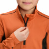 Ein Kind schließt einen orangefarbenen Pullover mit einem schwarzen Reißverschluss am Kragen.
