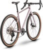 Ein rosafarbener Gravelbike-Rahmen mit braunen Reifen und schwarzen Komponenten.