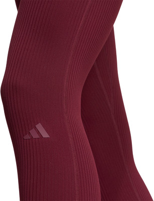 Detailaufnahme von dunkelweinroten Rippstrick-Leggings mit Adidas-Logo. Detailaufnahme von dunkelweinroten Rippstrick-Leggings mit Adidas-Logo.