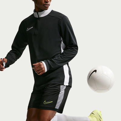 Fußballer im schwarzen Trikot und Shorts mit Ball am Fuß. Fußballer im schwarzen Trikot und Shorts mit Ball am Fuß.
