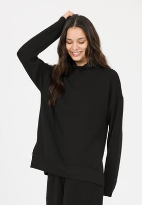 Eine Frau in einem schwarzen Rollkragenpullover mit langen Ärmeln. Eine Frau in einem schwarzen Rollkragenpullover mit langen Ärmeln.