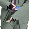 Eine Person in Skikleidung steckt eine Karte in eine Ärmeltasche.
