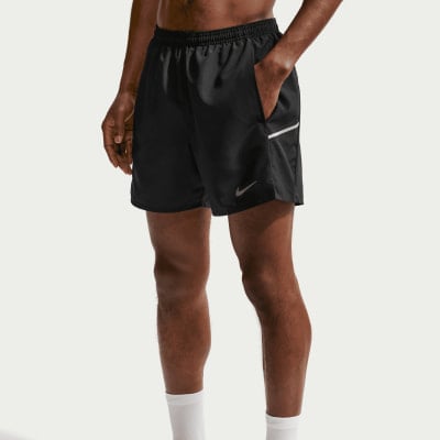 Mann in schwarzen Laufshorts mit Nike-Logo und weißem Streifen. Mann in schwarzen Laufshorts mit Nike-Logo und weißem Streifen.