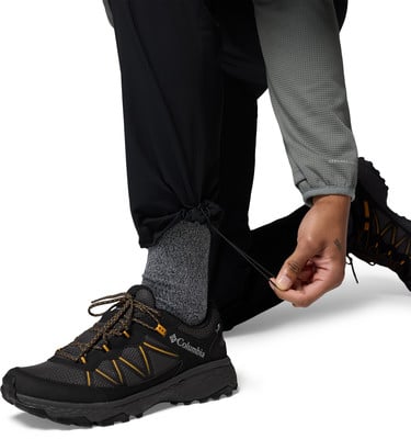 Eine Person zieht die Kordel des Hosenbeins fest und passt den Schuh an. Eine Person zieht die Kordel des Hosenbeins fest und passt den Schuh an.
