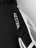 Detail eines Handschuhs mit HESTRA-Logo, schwarzer Stoff und weißes Leder.