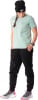 Frau in schwarzer Mütze, mintgrünem Shirt und schwarzer Jogginghose mit Turnschuhen.