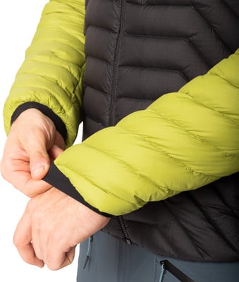 Detail einer Jacke in Schwarz und Grün, eine Person passt den Ärmel an. Detail einer Jacke in Schwarz und Grün, eine Person passt den Ärmel an.