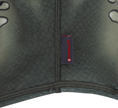 Grüner Stoff mit Camouflage-Muster und kleinem rotem Primaloft-Patch. Grüner Stoff mit Camouflage-Muster und kleinem rotem Primaloft-Patch.