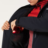 Ein Mann legt eine Skibrille in die innere Netztasche der Jacke.