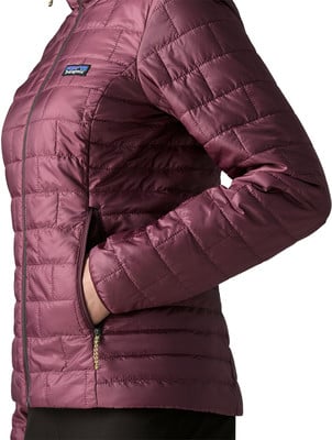Detail einer gesteppten Damenjacke mit Patagonia-Logo und Reißverschluss. Detail einer gesteppten Damenjacke mit Patagonia-Logo und Reißverschluss.