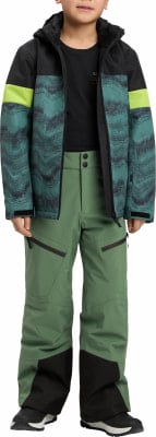 Junge in grüner Skihose und Jacke mit Print und Neongelb-Streifen.