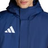 Ein Mann trägt eine dunkelblaue Kapuzenjacke mit weißem Adidas-Logo.