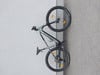 Graues Mountainbike, das an einer weißen Wand lehnt, Vorder- und Hinterrad sichtbar.