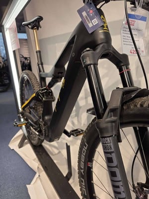 Schwarzes E-Bike mit Federung und Preisschild für 420 EUR. Schwarzes E-Bike mit Federung und Preisschild für 420 EUR.