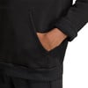 Detail einer Hand in der Tasche eines schwarzen Hoodies mit Fleece-Bündchen.