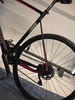 Das Hinterrad eines schwarzen Fahrrads mit roten Details und Scheibenbremse.