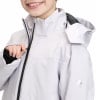 Ein Mädchen schließt eine weiße Jacke mit schwarzem Reißverschluss und McKinley-Logo.