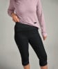Frau in einem rosa Langarmshirt und schwarzen 3/4 Hosen.