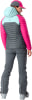 Eine Frau in Skibekleidung mit einer pinken Jacke und grauer Hose.