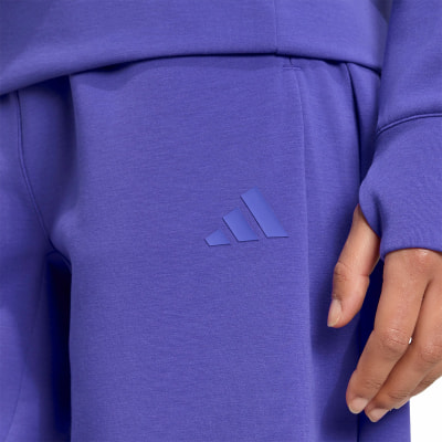 Lila Trainingshose mit Adidas-Logo an der Seite. Lila Trainingshose mit Adidas-Logo an der Seite.
