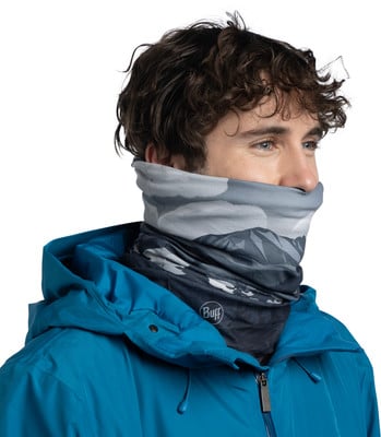 Mann in blauer Jacke und einem Multifunktionstuch mit Bergmotiv. Mann in blauer Jacke und einem Multifunktionstuch mit Bergmotiv.