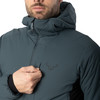 Mann in einer dunkelblauen Winterjacke mit Kapuze und Logo.