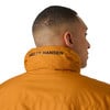Férfi narancssárga dzsekiben, Helly Hansen logóval a galléron.