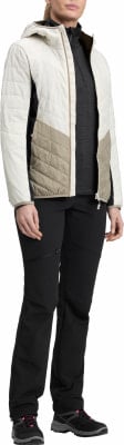 Frau in gesteppter Jacke und schwarzer Hose mit Wanderschuhen. Frau in gesteppter Jacke und schwarzer Hose mit Wanderschuhen.