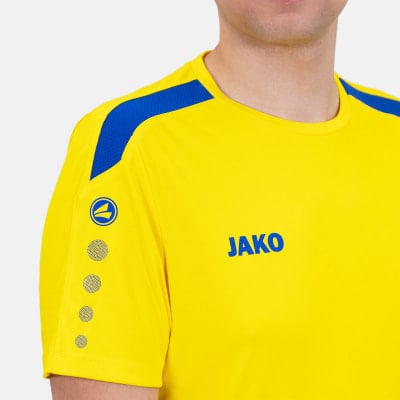 Gelbes Trikot mit blauen Akzenten und JAKO-Logo auf der Brust. Gelbes Trikot mit blauen Akzenten und JAKO-Logo auf der Brust.