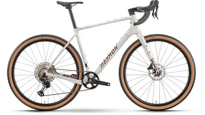 Graues RAYMON Gravelbike mit braunen Reifen und schwarzen Komponenten. Graues RAYMON Gravelbike mit braunen Reifen und schwarzen Komponenten.