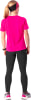 Eine Frau in einem pinken Shirt und schwarzen Leggings mit Stirnband.