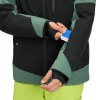 Ein Mann steckt eine Karte in eine Ärmeltasche einer Jacke.