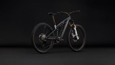 Ein graues Cube E-Mountainbike mit Federung und schwarzen Rädern.