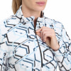 Eine Frau schließt eine weiße Fleecejacke mit blauem geometrischem Muster.