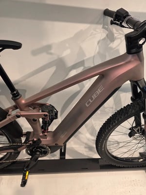 Ein rosafarbenes Cube E-Bike mit Federung und robustem Rahmen. Ein rosafarbenes Cube E-Bike mit Federung und robustem Rahmen.