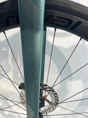 Grüne Fahrradgabel mit Bremsscheibe und Felge