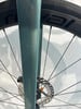 Grüne Fahrradgabel mit Bremsscheibe und Felge
