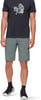 Ein Mann in einem schwarzen T-Shirt mit Aufdruck und grauer Hose mit Mammut-Logo.