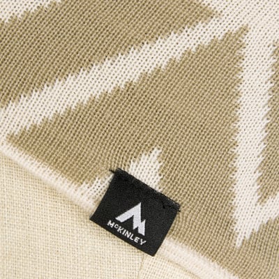 Detail eines Strickmusters mit McKinley-Logo auf schwarzem Etikett. Detail eines Strickmusters mit McKinley-Logo auf schwarzem Etikett.