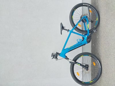 Ein blaues E-Mountainbike mit schwarzen Rädern steht an einer Wand. Ein blaues E-Mountainbike mit schwarzen Rädern steht an einer Wand.