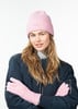 Frau mit rosa Mütze und Handschuhen in dunkelblauer Jacke.