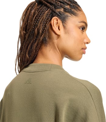 Detail eines Damen-T-Shirts mit Adidas-Logo auf dem Rücken, Haar-Detail mit Zöpfen.