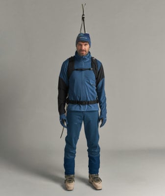 Ein Mann in Skikleidung steht mit Skiern auf dem Kopf. Ein Mann in Skikleidung steht mit Skiern auf dem Kopf.