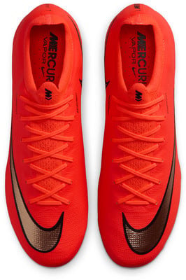 Rote Nike Fußballschuhe mit bronzenem Logo und Schnürsenkeln. Rote Nike Fußballschuhe mit bronzenem Logo und Schnürsenkeln.