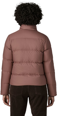 Rückansicht einer Person in einer gesteppten Jacke und braunen Cordhosen. Rückansicht einer Person in einer gesteppten Jacke und braunen Cordhosen.