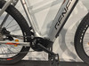 Detail eines E-Mountainbikes mit Genesis- und BOSCH-Logo, schwarzen Pedalen und Kette.