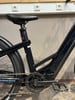 Teil eines dunkelblauen E-Bikes mit sichtbarer Kette und Pedal.
