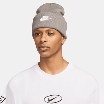Ein Mann in einer grauen Nike-Mütze mit Logo und einem weißen T-Shirt mit Aufdruck.